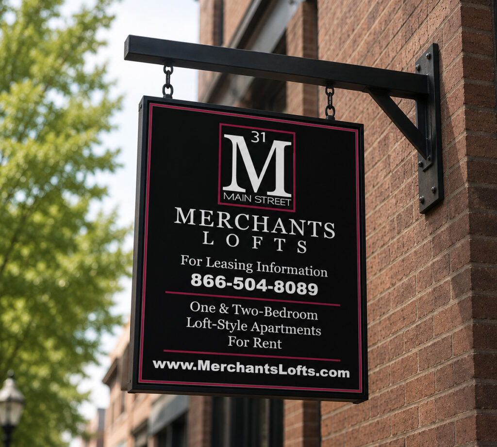 Black, white and red Merchants Lofts hanging sign on side of a brick building